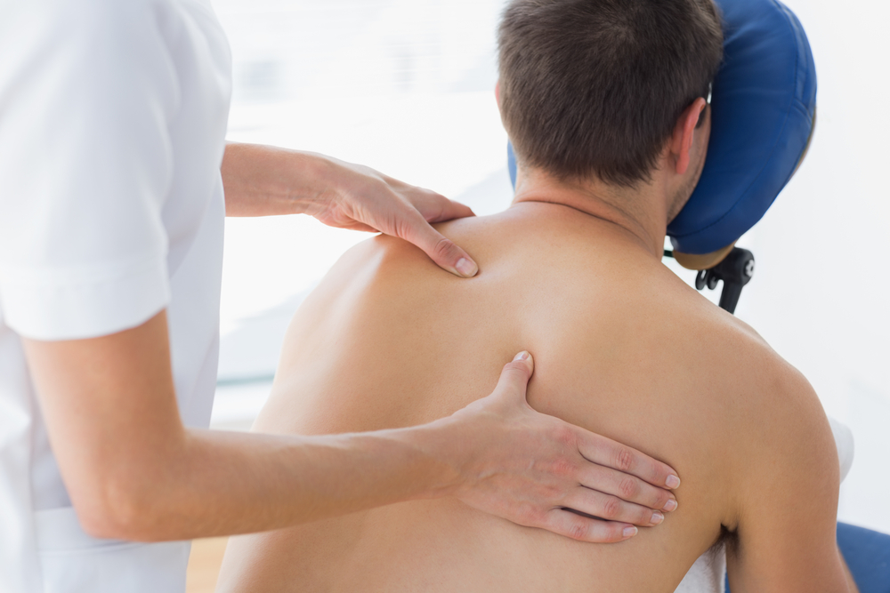 Massage assis sur le dos appuyant sur les zones sensibles